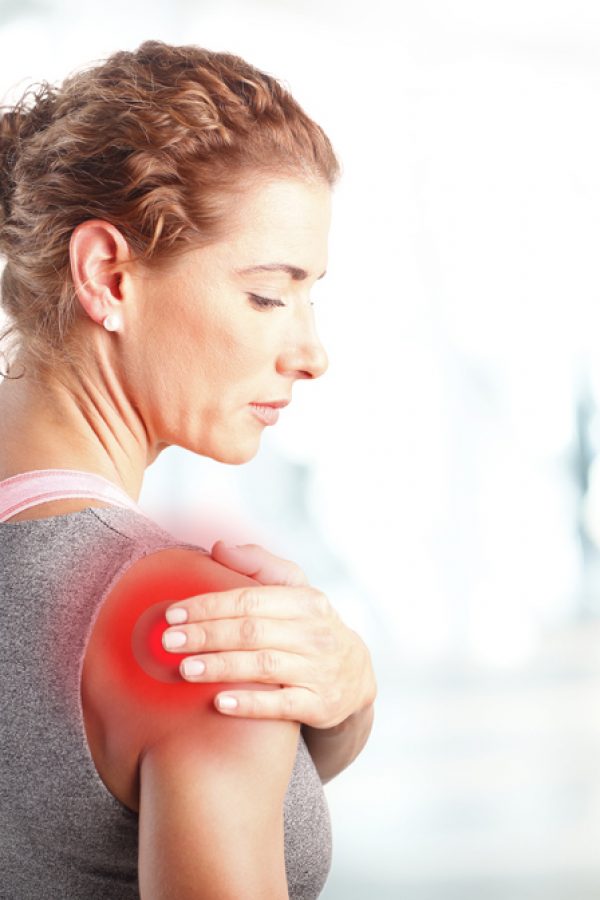 Portrait of sporty woman putting her hand on red spots on while has sport injury in her shoulder.
